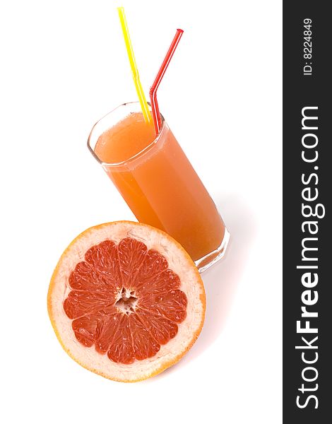 Half of grapefruit and juice in glass on white
