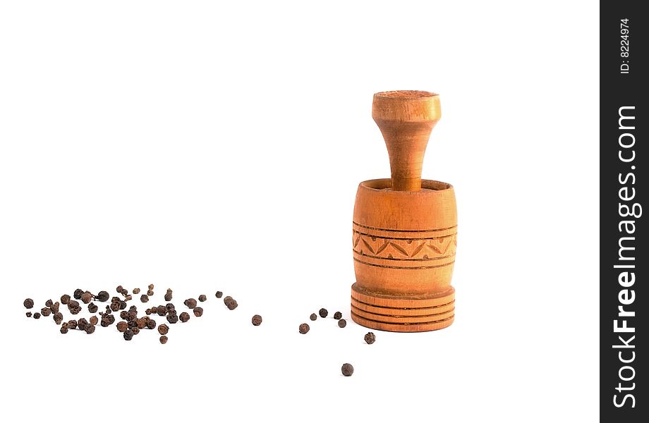 Old pepper mill with black pepper isolated in white background