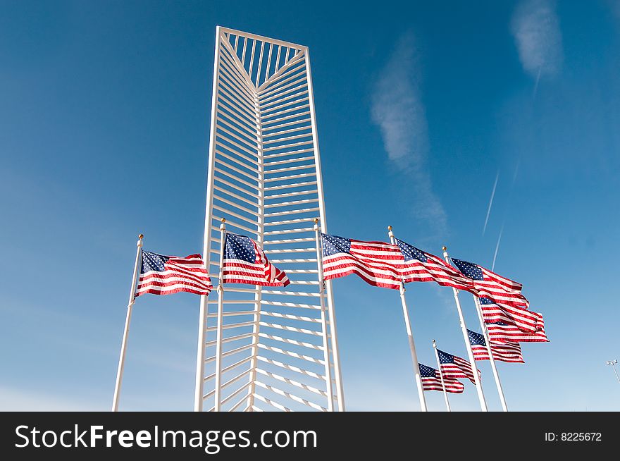 Two American flags frame a tall monument.