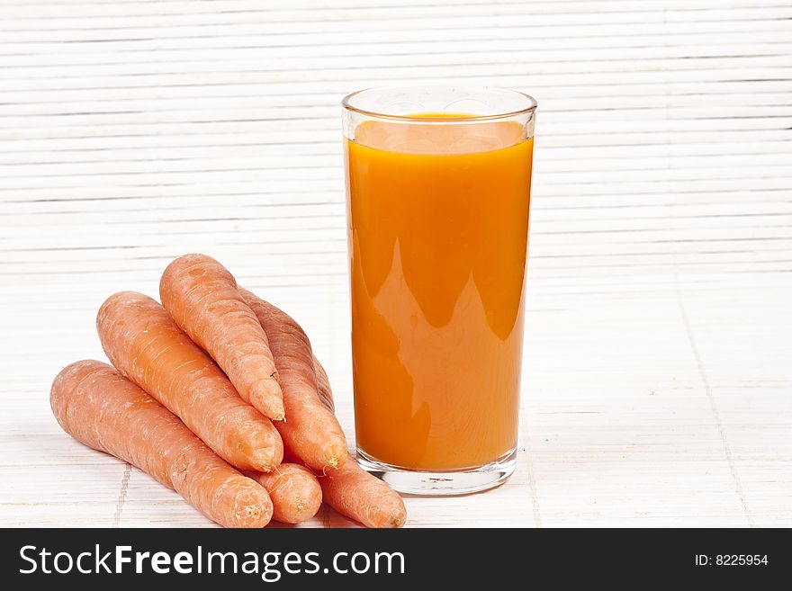 Carrot juice and carrots on the table