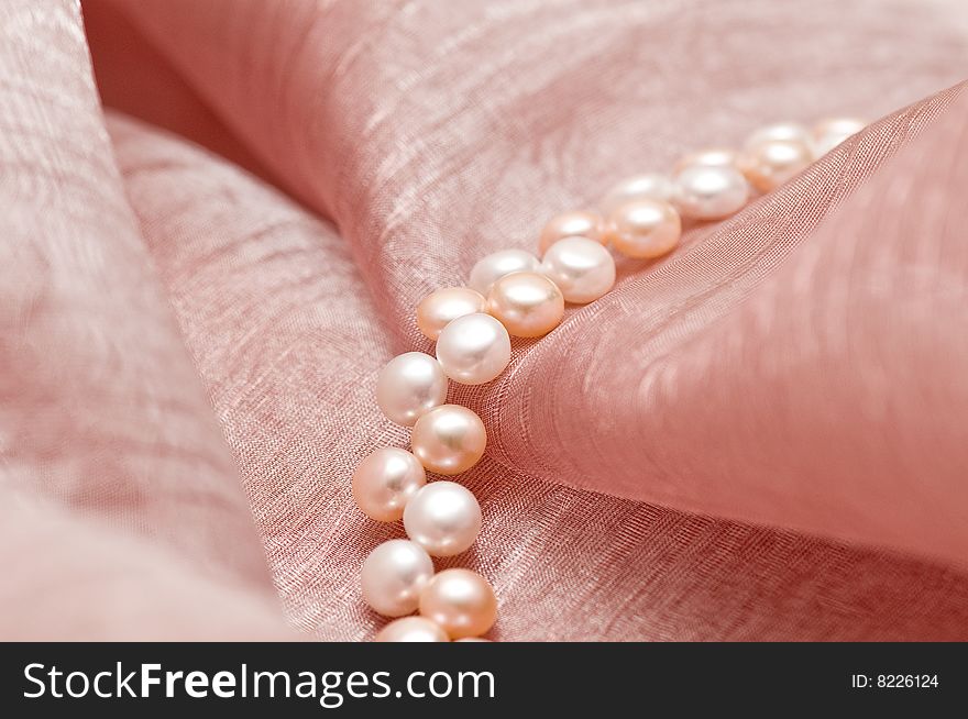 Beads of pearl on the pink background
