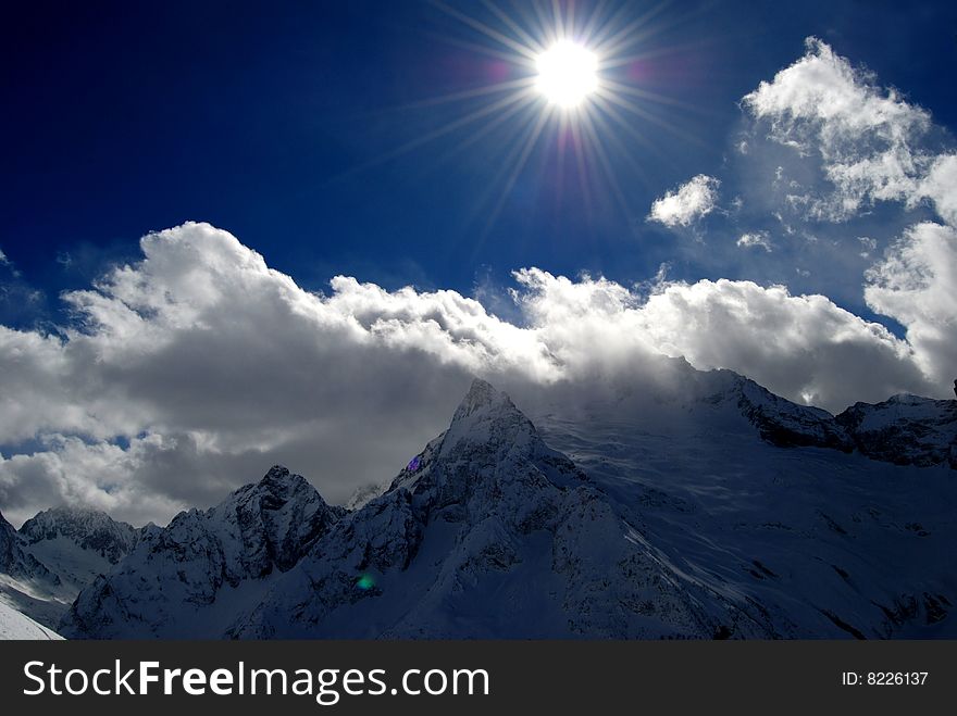 Beautiful view of winter mountains and bright blue sun. Beautiful view of winter mountains and bright blue sun