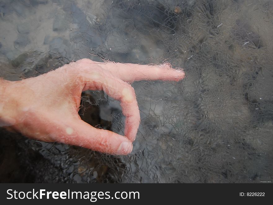 Image illustrates the most popular finger position (It's OK) in the art manner. This is a hand under the ice. It is winter. It's Kazhdan Valeriy's hand (autor of the photo).