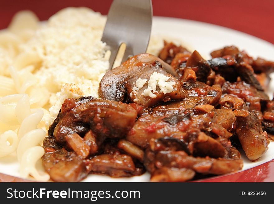 Close-up of tasty pasta with mushrooms on the white plate