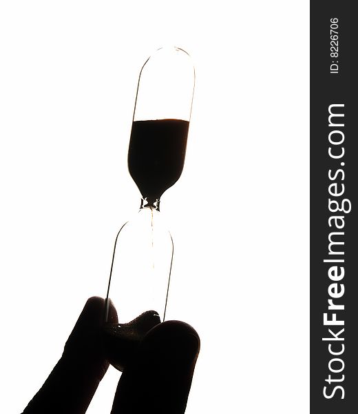 Retro hourglasses in hand backlit vertical isolated. Retro hourglasses in hand backlit vertical isolated