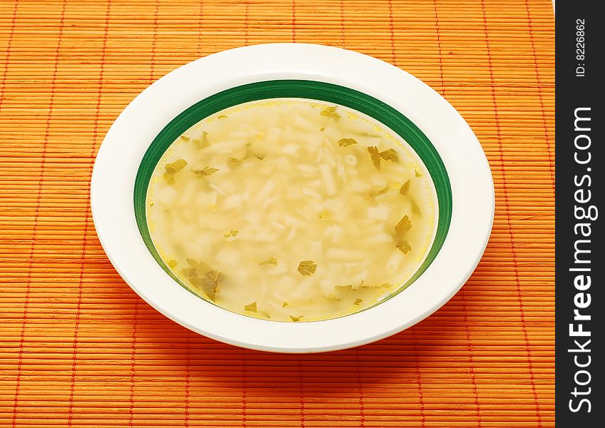 Soup in a plate on bamboo mat