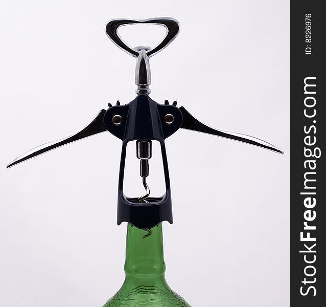 Corkscrew at the neck of the bottle green