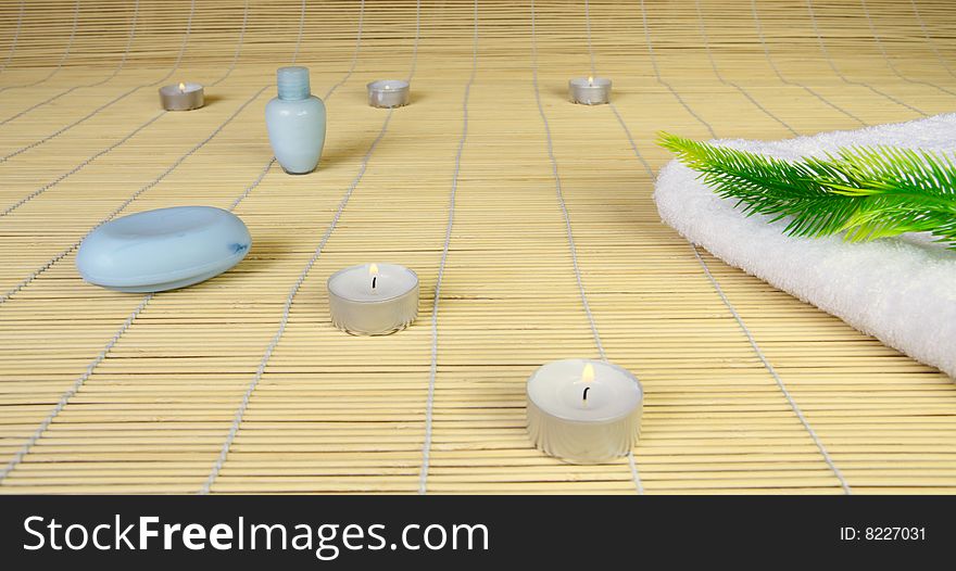 Spa objects: candles, soap, towel and plant.