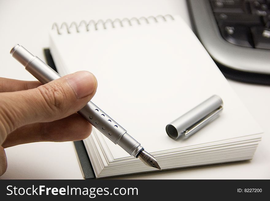 Offering a pen to take notes in an office environment. Offering a pen to take notes in an office environment