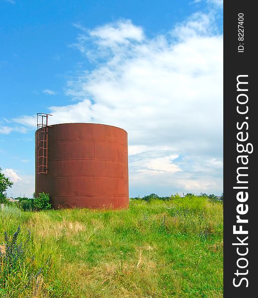 Iron cistern on the field (bright photo)