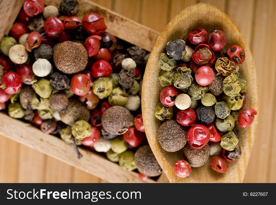 Wooden spoon full of aromatic peppers