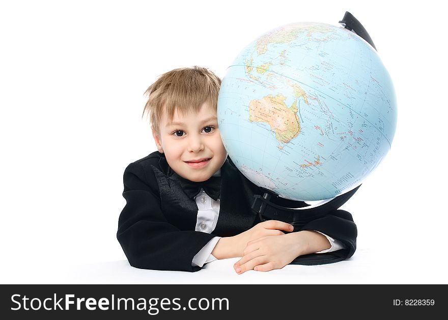 Happy schoolboy sitting by the table and embracing a big globe. Happy schoolboy sitting by the table and embracing a big globe