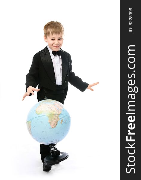 Happy playful  little schoolboy balancing a globe on his foot and pretending he is playing football. Happy playful  little schoolboy balancing a globe on his foot and pretending he is playing football