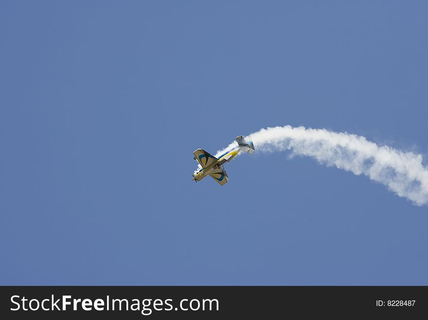 A R/C model airplane doing stunts and emitting smoke