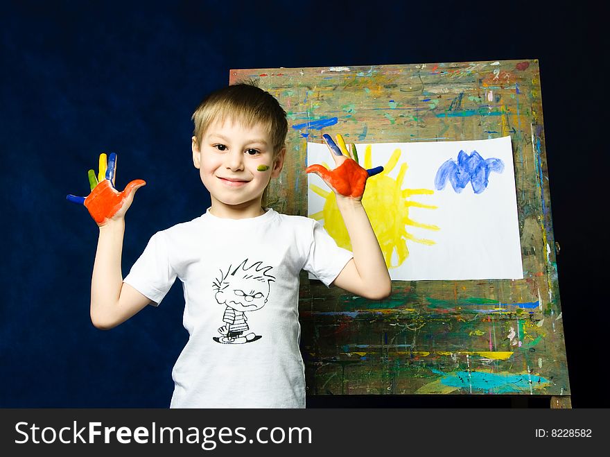 Happy smiling little boy standing near the easel and showing his fingers. Happy smiling little boy standing near the easel and showing his fingers
