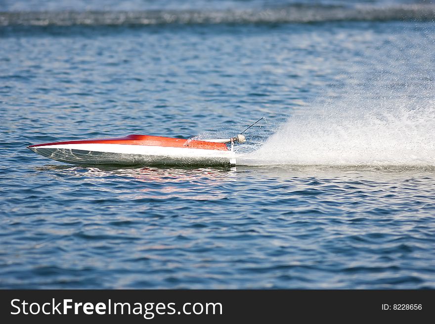 An R/C model boat doing practice laps and running fast. An R/C model boat doing practice laps and running fast