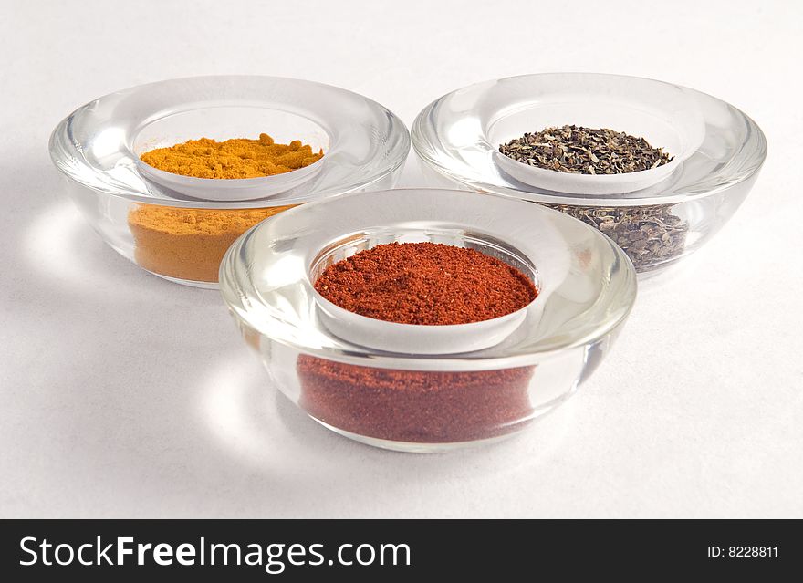 Three colorful spices in glass containers closeup