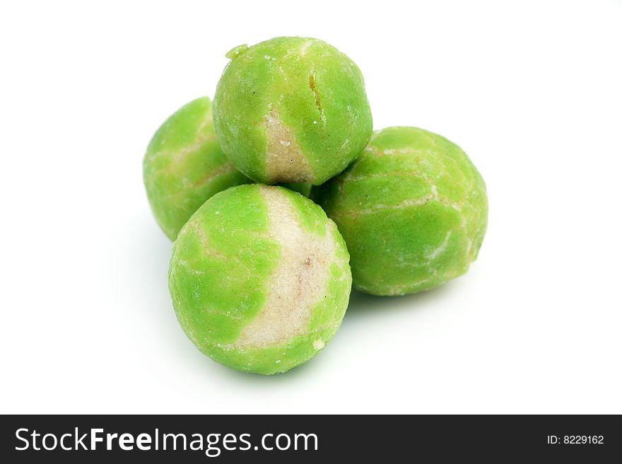 A pile of wasabi green pea snack balls isolated over white background. A pile of wasabi green pea snack balls isolated over white background.