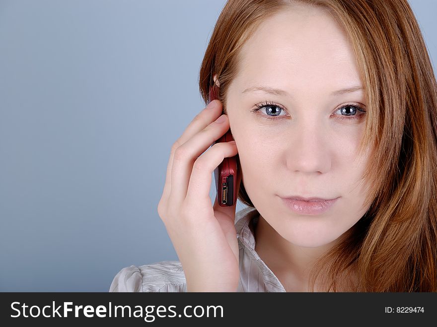 The young woman speaks on the phone with copy space