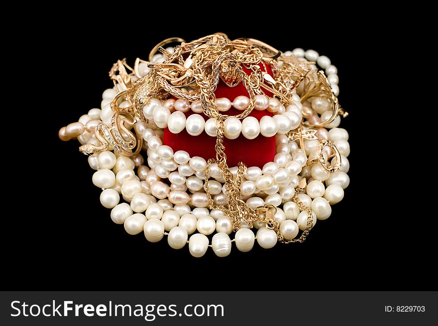 Handful of gold and pearls isolated on a black background
