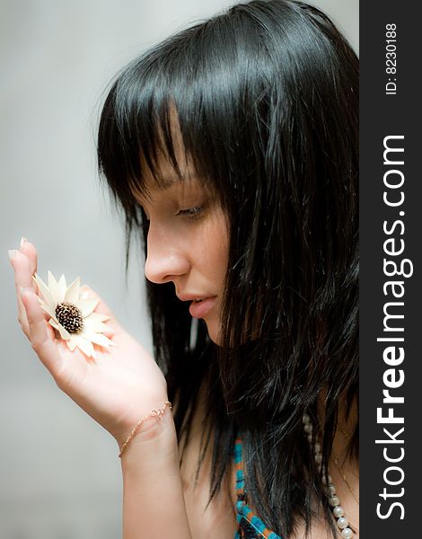 Beautiful girl with artificial flower in her hand. Beautiful girl with artificial flower in her hand