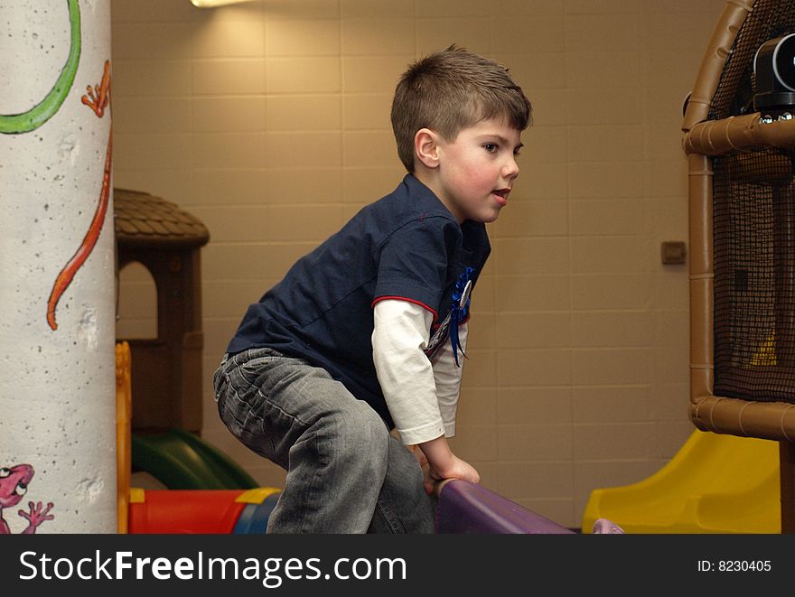 Young boy having fun at an indoor play ground on his fifth birthday