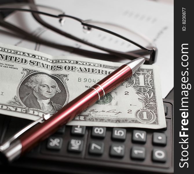 Calculator,one dollar,pen and glasses. Calculator,one dollar,pen and glasses