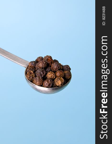 Image of table spoon with black pepper seeds. Image of table spoon with black pepper seeds