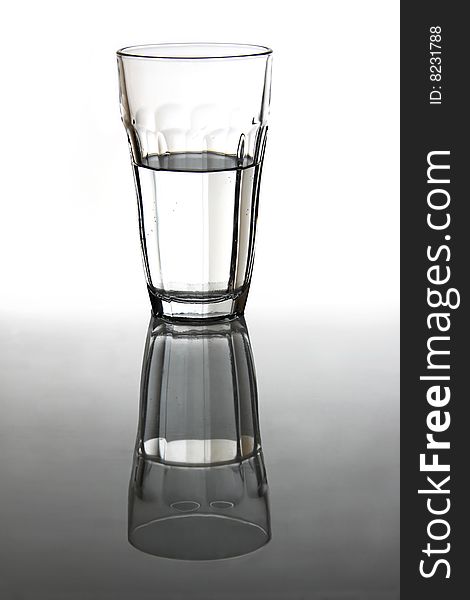 A glass of water with reflection isolated on white.