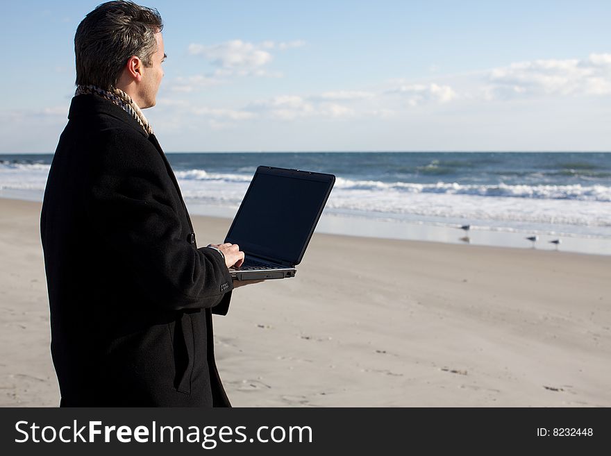 Businessman trying to get inspired looking at the sea and working on his laptop. Businessman trying to get inspired looking at the sea and working on his laptop