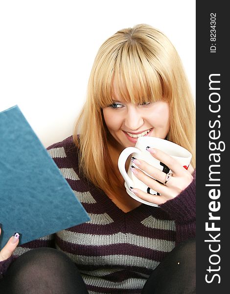 Portrait of a  young lady reading book with  cup in hand. Portrait of a  young lady reading book with  cup in hand