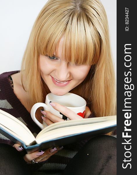 Portrait of a  young lady reading book with  cup in hand. Portrait of a  young lady reading book with  cup in hand