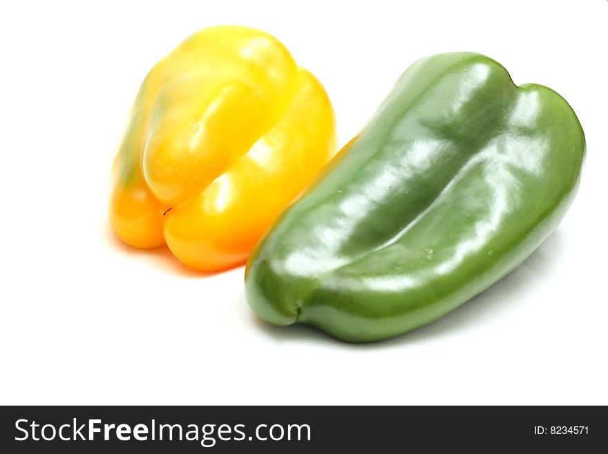 Green and yellow peppers isolated on white, shallow DOF, focus on point of the yellow pepper