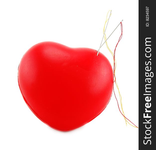 Heart shaped pincushion with two needles isolated on a white background