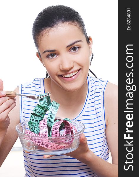 Portrait of a young woman eating measuring tape with a fork. Portrait of a young woman eating measuring tape with a fork