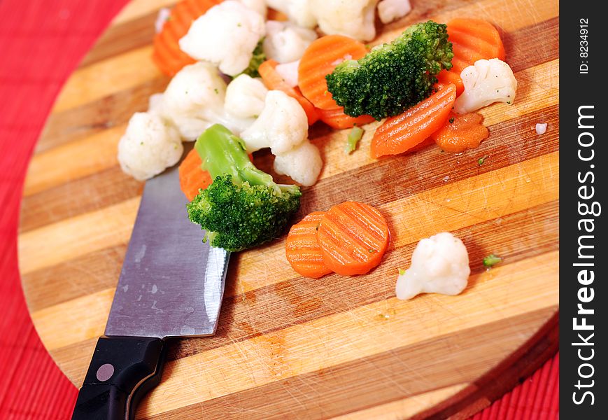 Wood board with knife and cut fresh vegetables. Wood board with knife and cut fresh vegetables