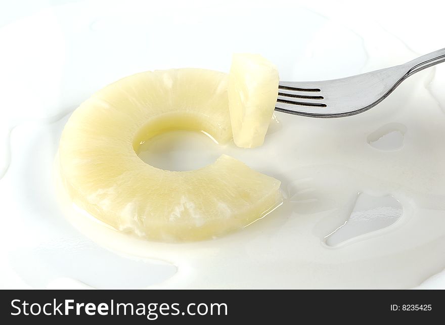 Slice of pineapple with liquid and fork
