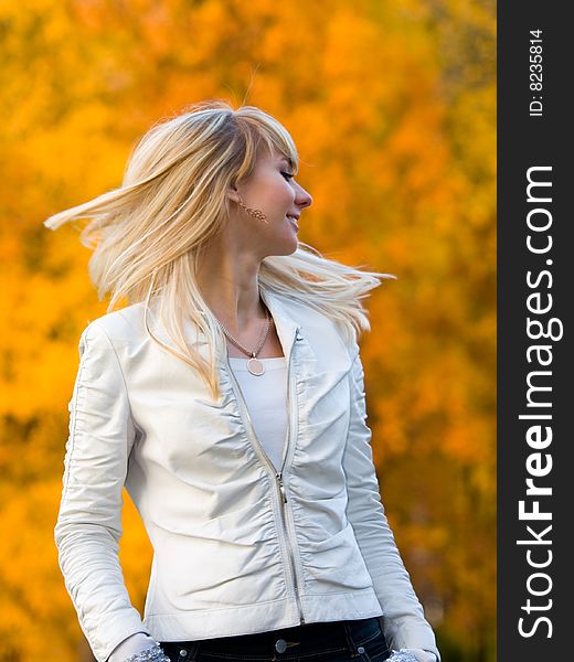 Pretty girl in white jacket on autumn park background - shallow DOF