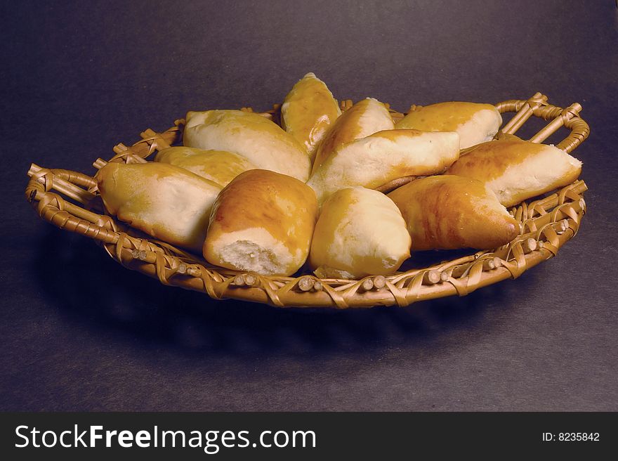 Wooden dish with home patties on a dark background