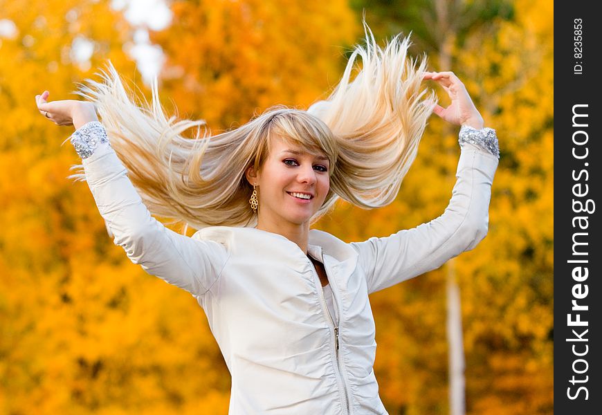 Pretty girl in white jacket on autumn park background - shallow DOF