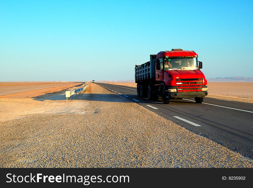 Red truck in the highway in the desert