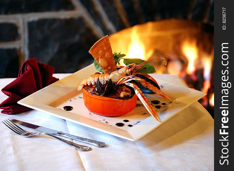 A delicious lobster, served by an open fire and ready to be eaten.