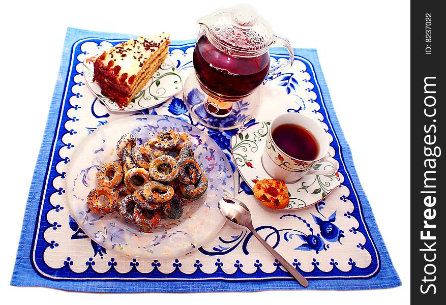 Teapot with a steep sealed tea, spilling a cup of tea, next a piece of home-made cake. Teapot with a steep sealed tea, spilling a cup of tea, next a piece of home-made cake.