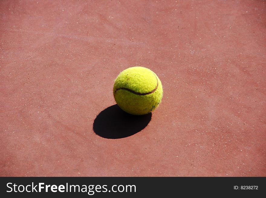 Yellow tennis ball left on the ground