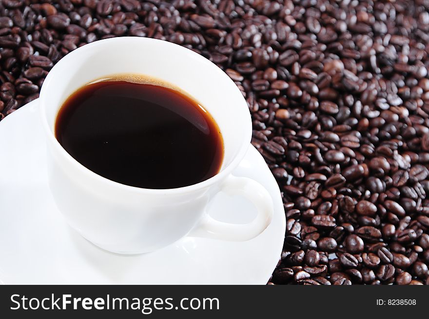 Black coffee in a white cup on a background coffee grain