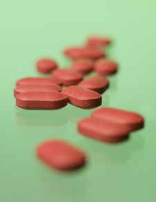 Red Pills Toward Green Background Royalty Free Stock Image
