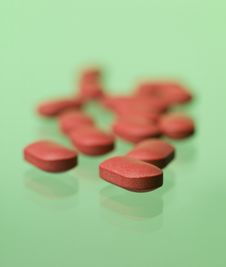 Red Pills Toward Green Background Stock Photography