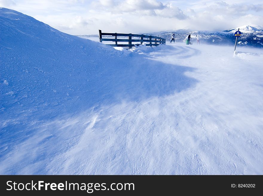 Snow covered mountain with few skiers in the background