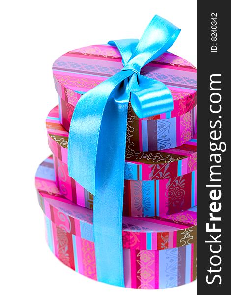 Pyramid of colorfull gift boxes with blue bow closeup on white background