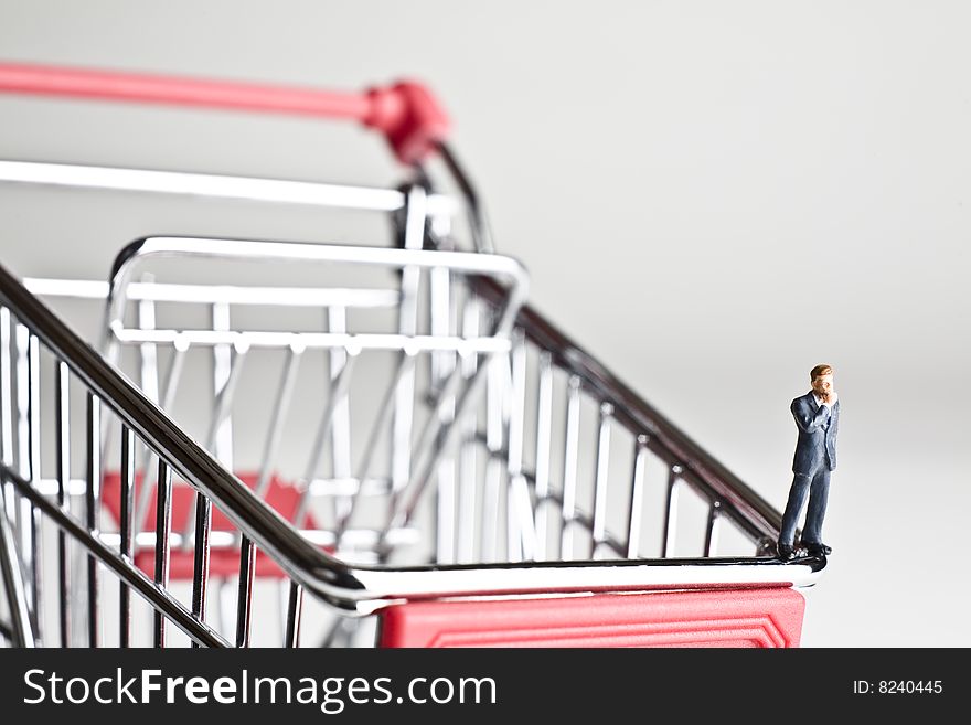 Businessman figurines standing on a shopping cart. Businessman figurines standing on a shopping cart